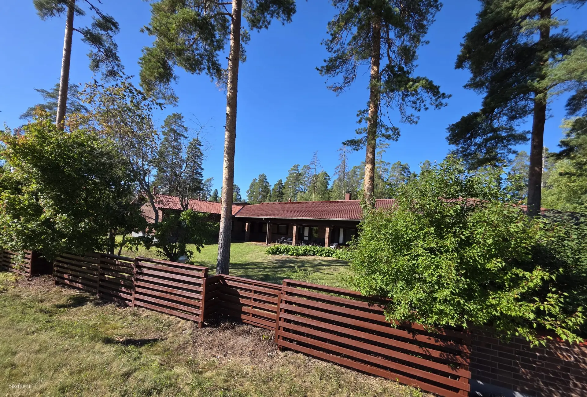 Villa Hollola ulkoa – punatiilinen talo mäntyjen keskellä
